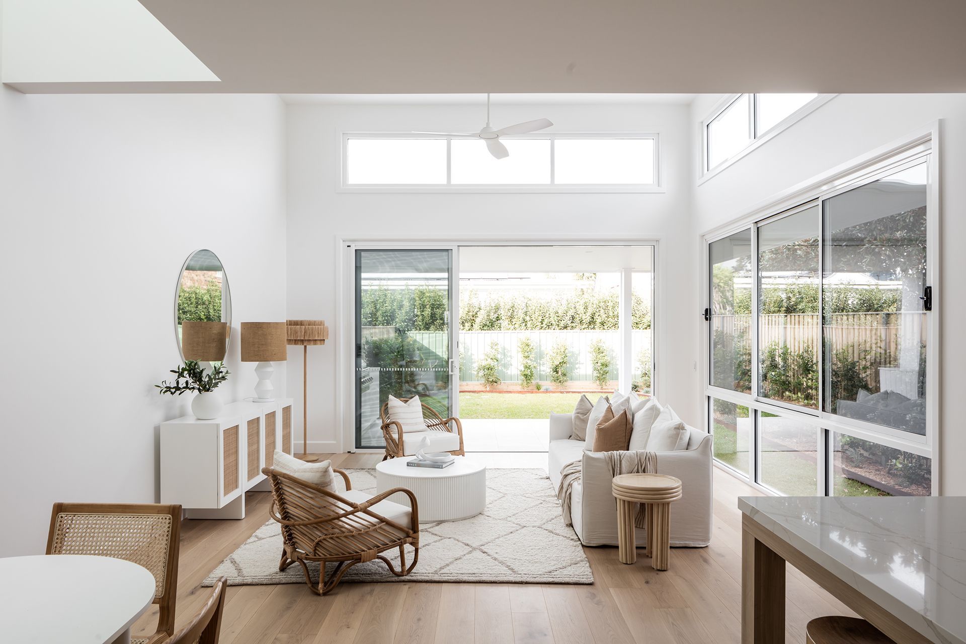 A living room with a couch, chair, table and sliding glass doors.