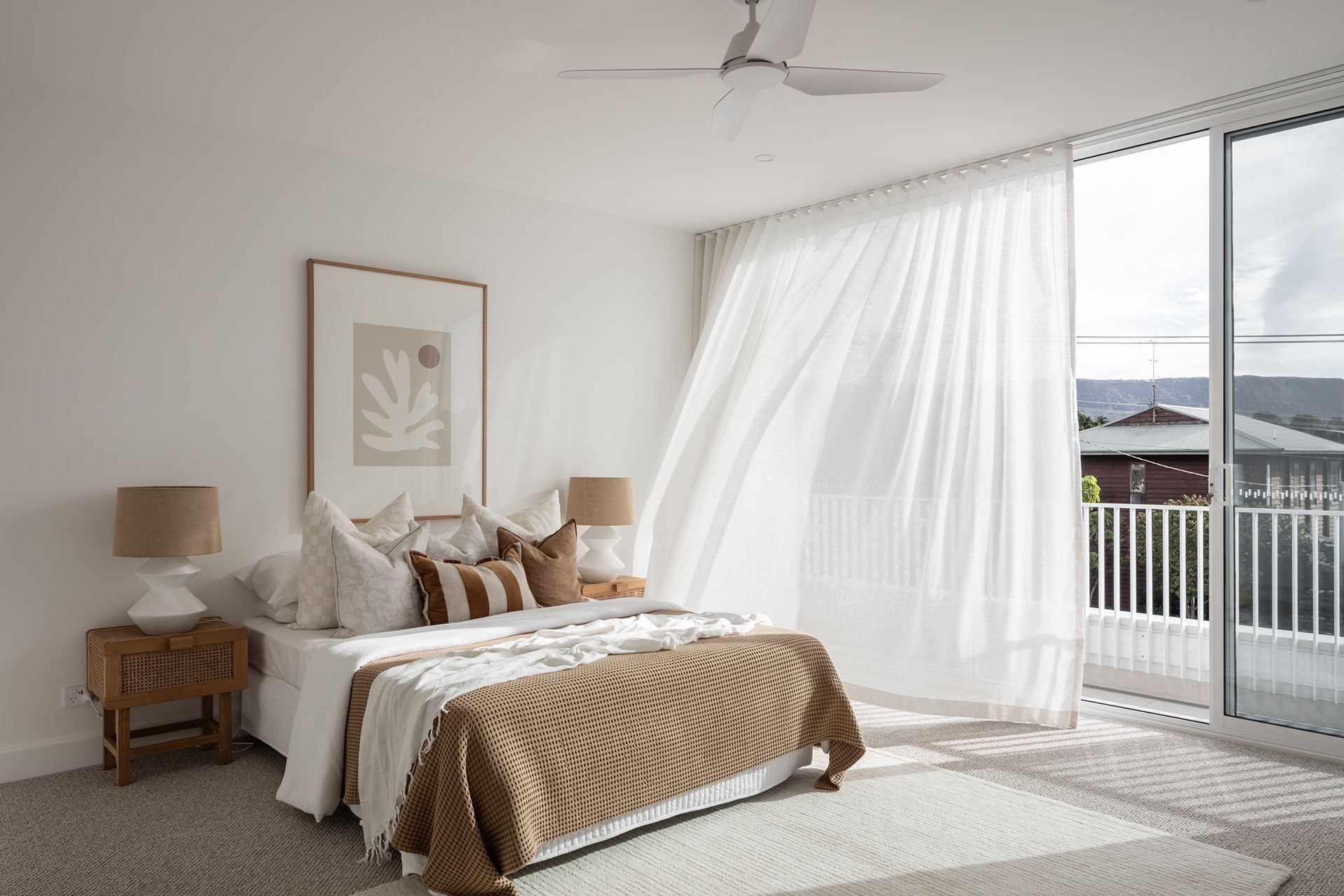 A bedroom with a large bed and a ceiling fan.