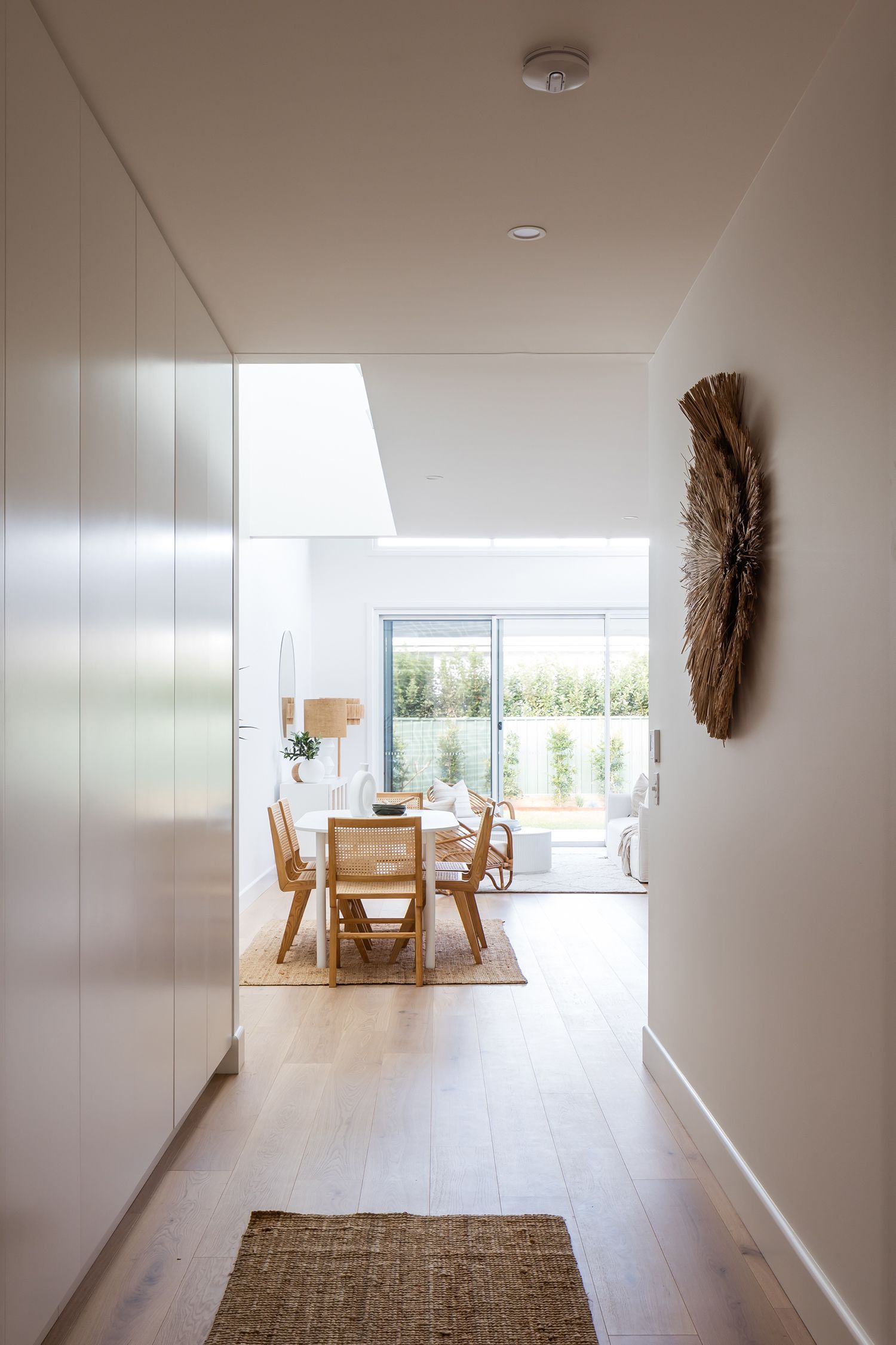 Kareela Road project's hallway leading to a dining room with a table and chairs.