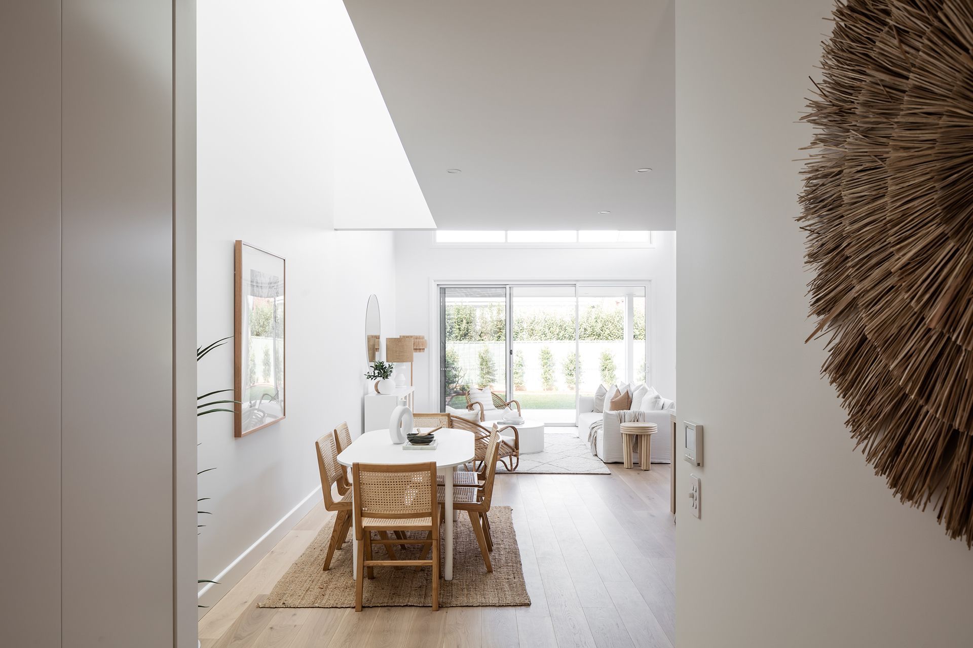 A dining room with a table and chairs and a large window.