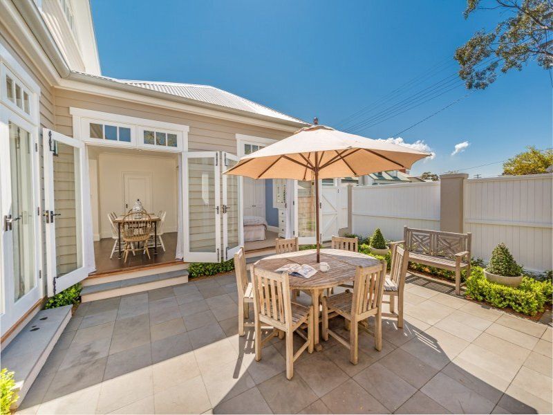 A patio with a table and chairs and an umbrella