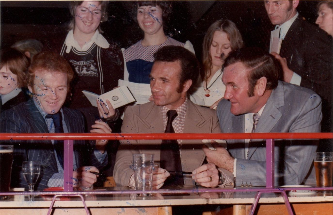 A group of people sitting at a table with glasses of water