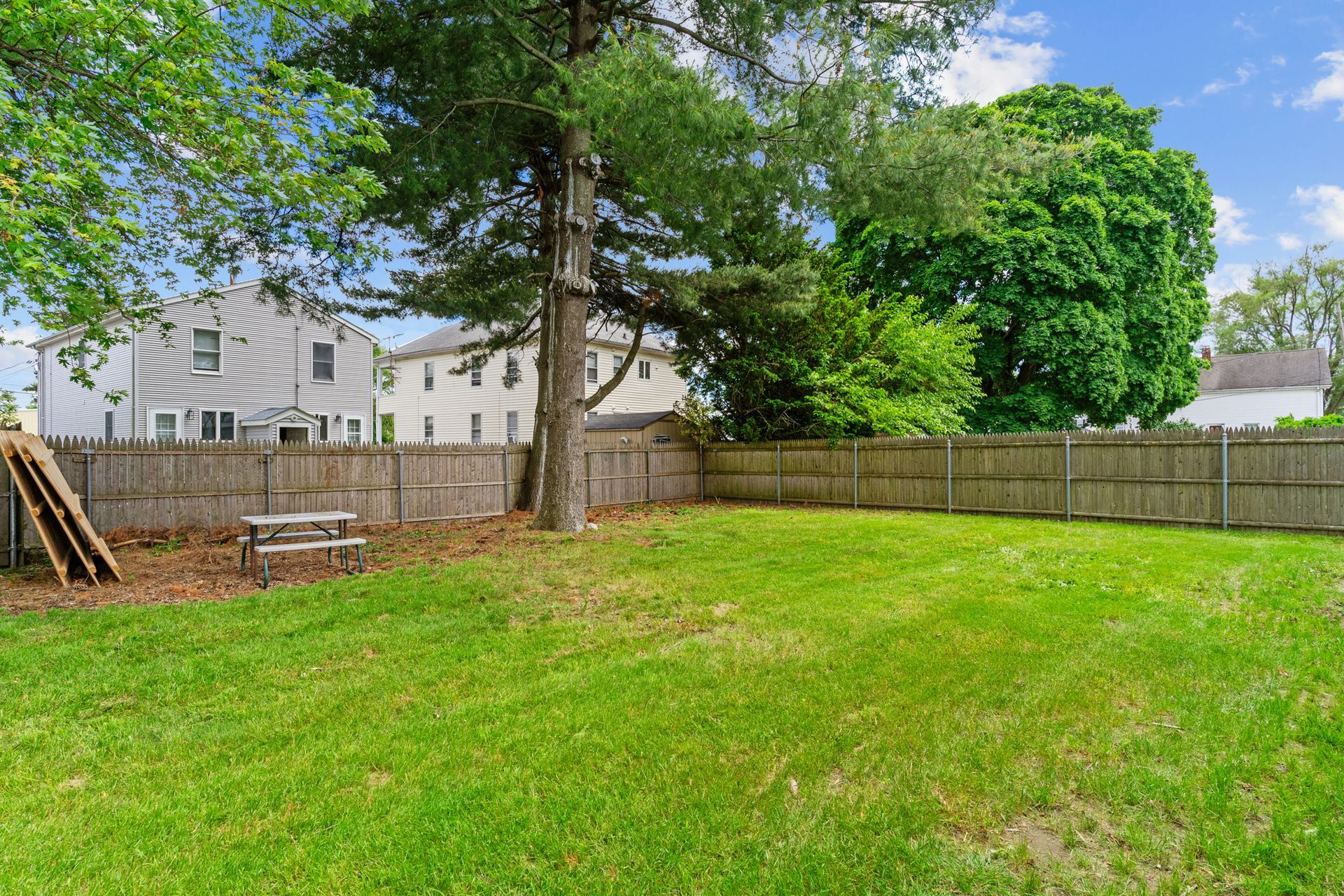 There is a picnic table in the backyard of a house.