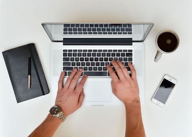 A person is typing on a laptop computer to request a quote.