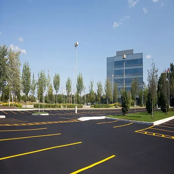 An empty parking lot with a large building in the background.