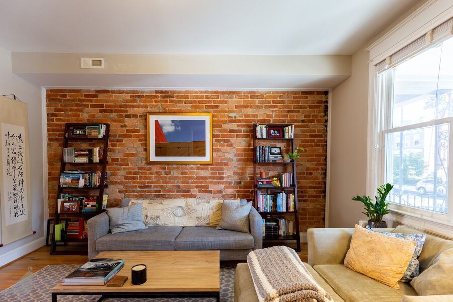 DC living room with couch and exposed brick, highlighting local rental property market.