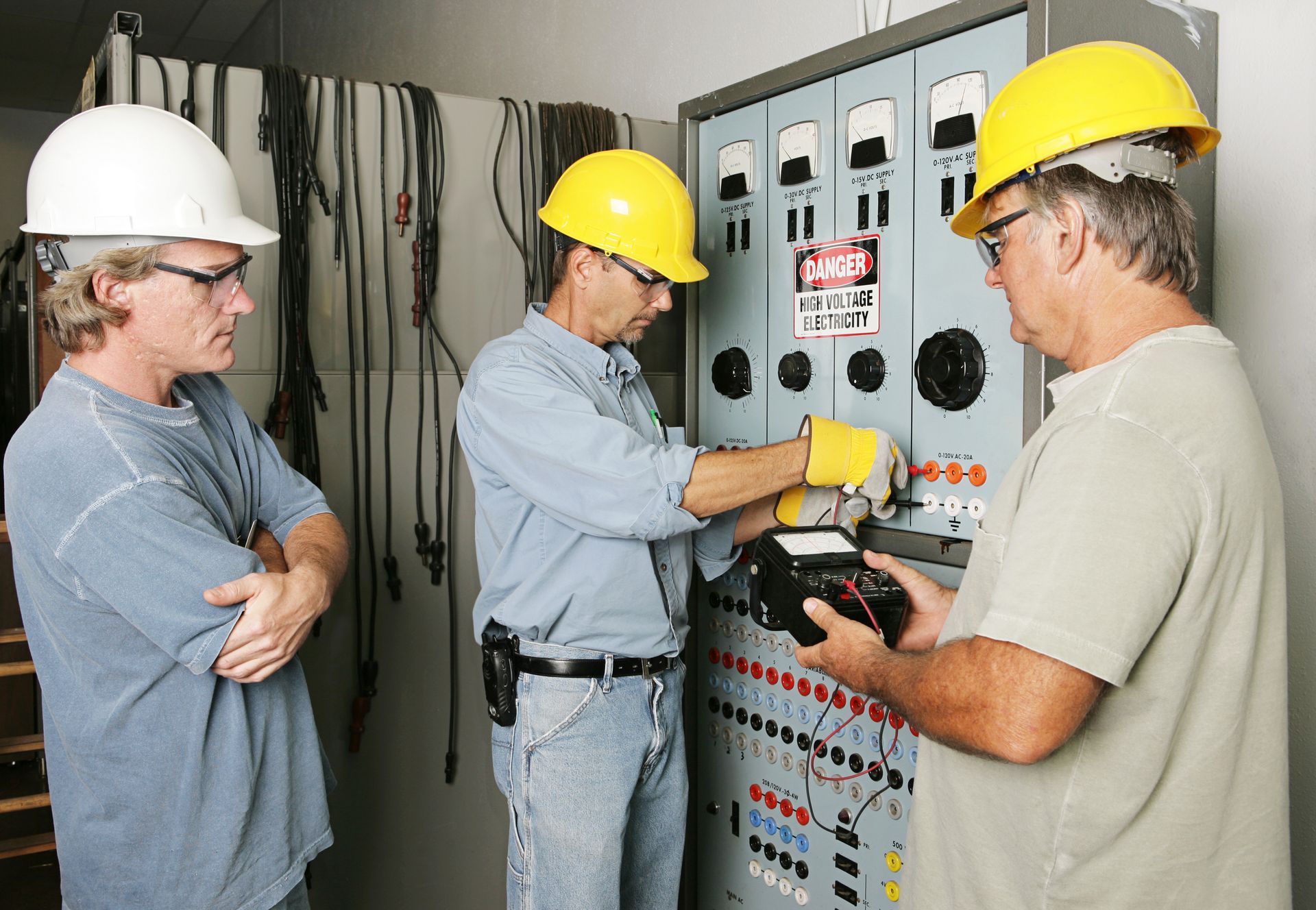 Industrial electricians inspecting a control panel. Industrial electricians inspecting a control panel.