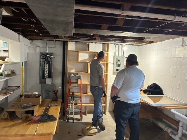 A professional technicians strategizing integrating circuits into a relocated service panel    for reliable residential electrical services.