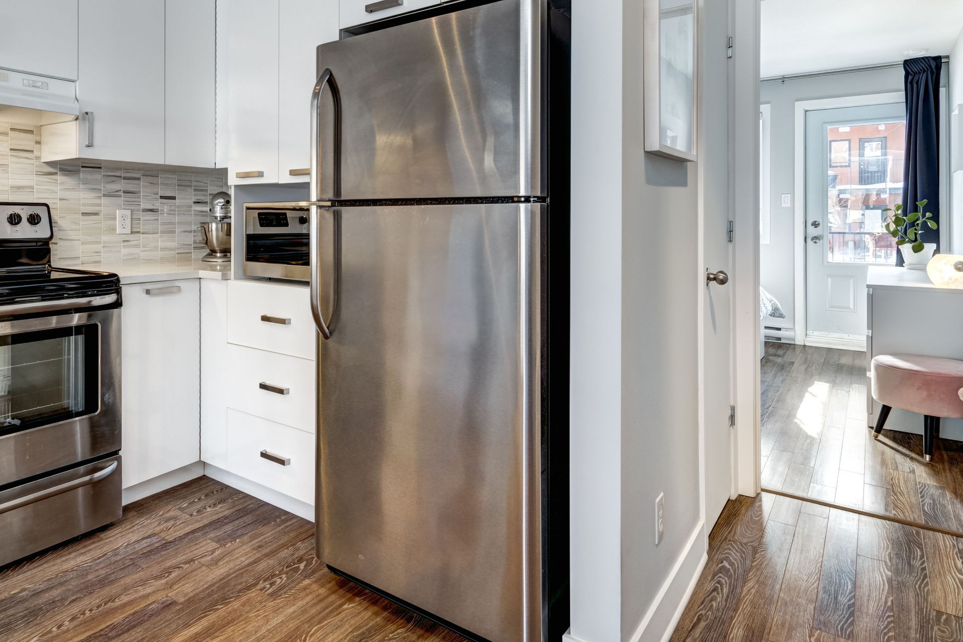A kitchen with a stainless steel refrigerator and stove