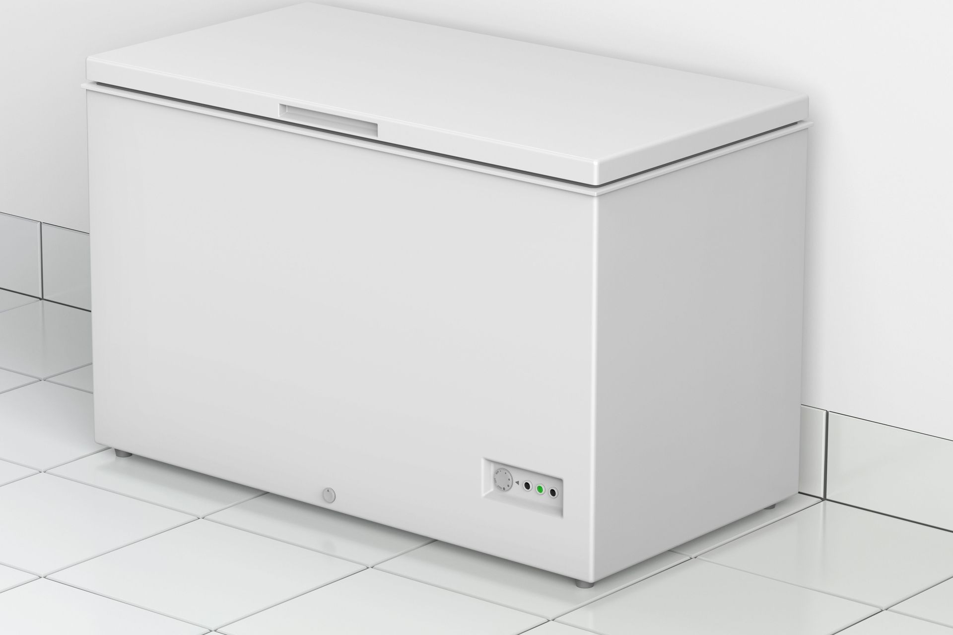 A white freezer is sitting on a tiled floor next to a wall.