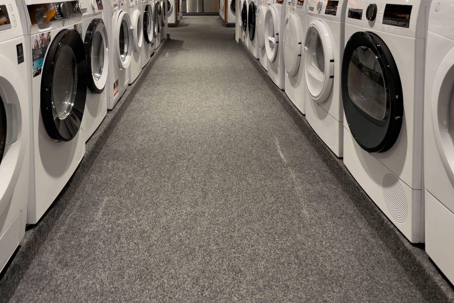 A row of washing machines are lined up in a laundromat.