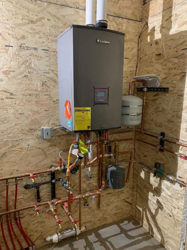A water heater is installed in a room with pipes.