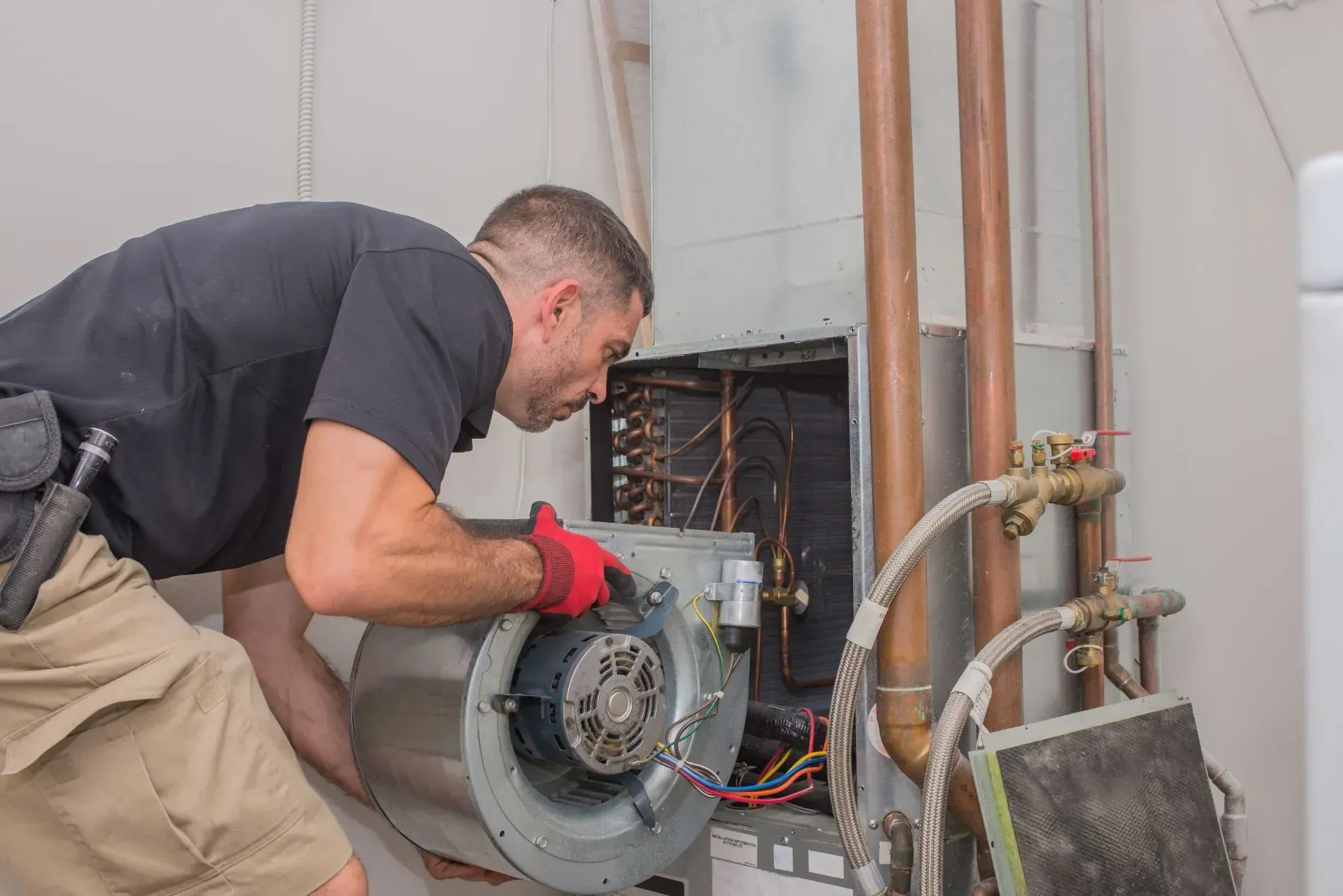A man is working on an air conditioner in a room.