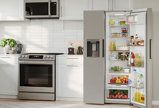 A kitchen with a stove , refrigerator , and microwave.