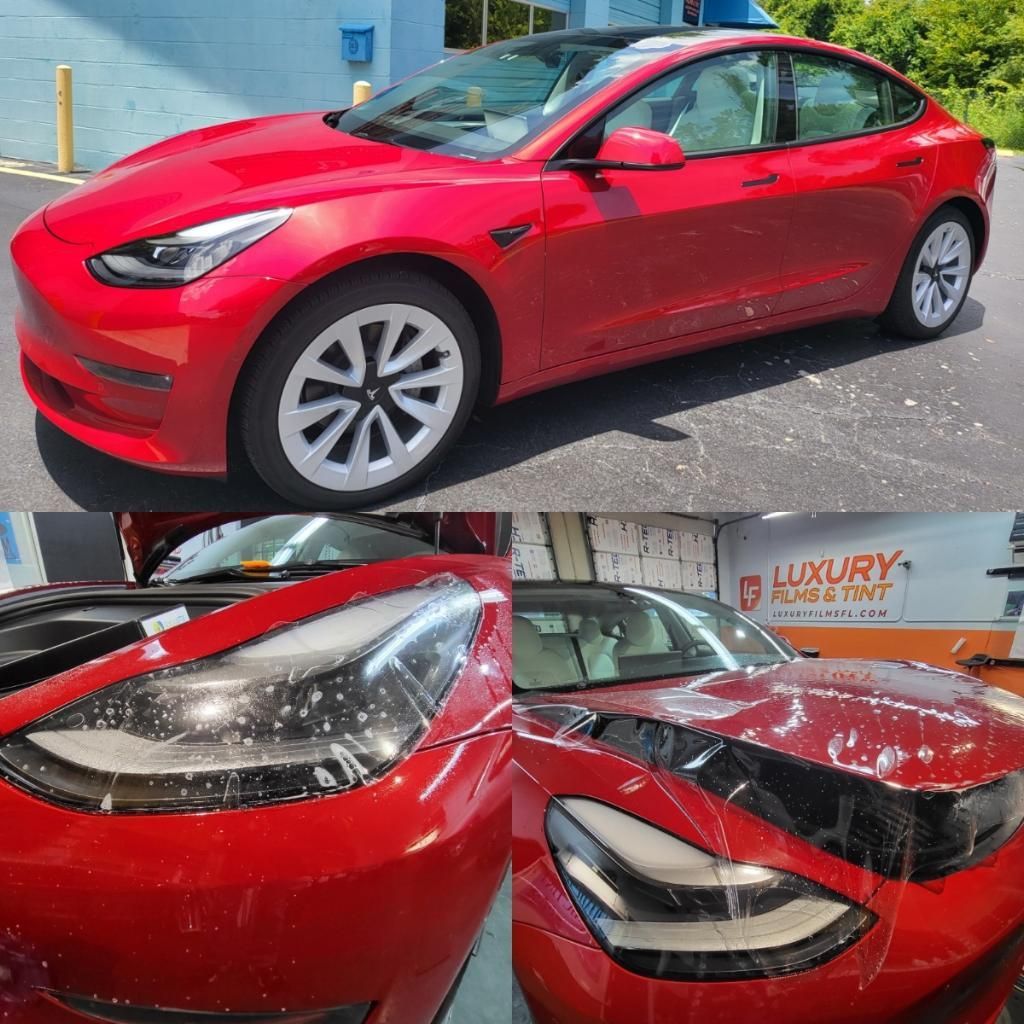 A red tesla model 3 is parked in a parking lot