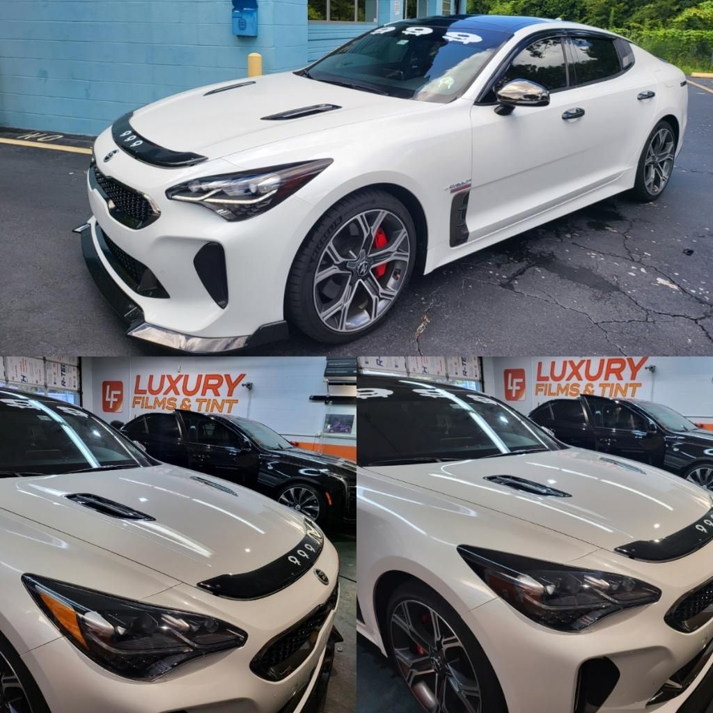 A white car is parked in front of a building that says luxury films & tint