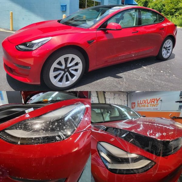 A man is wrapping a red car with plastic wrap.