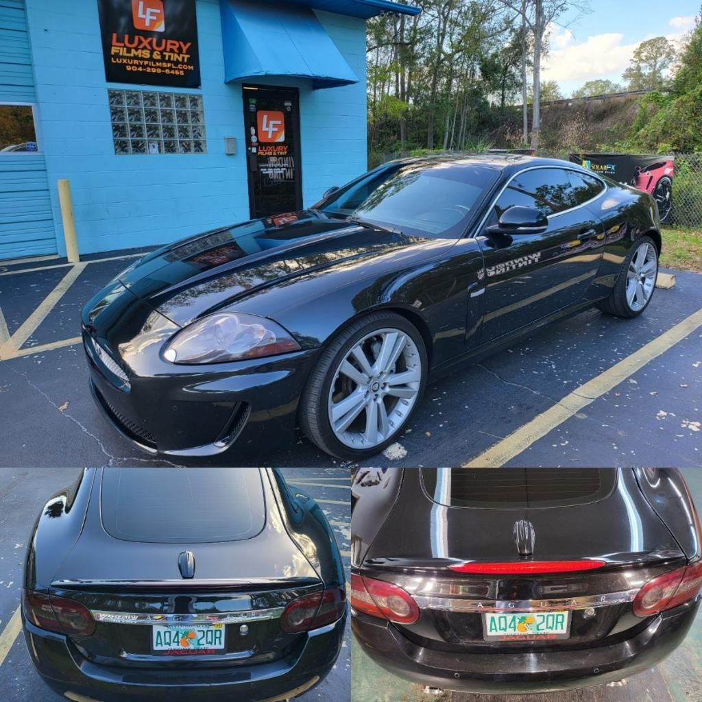 A black sports car is parked in front of a luxury auto body shop