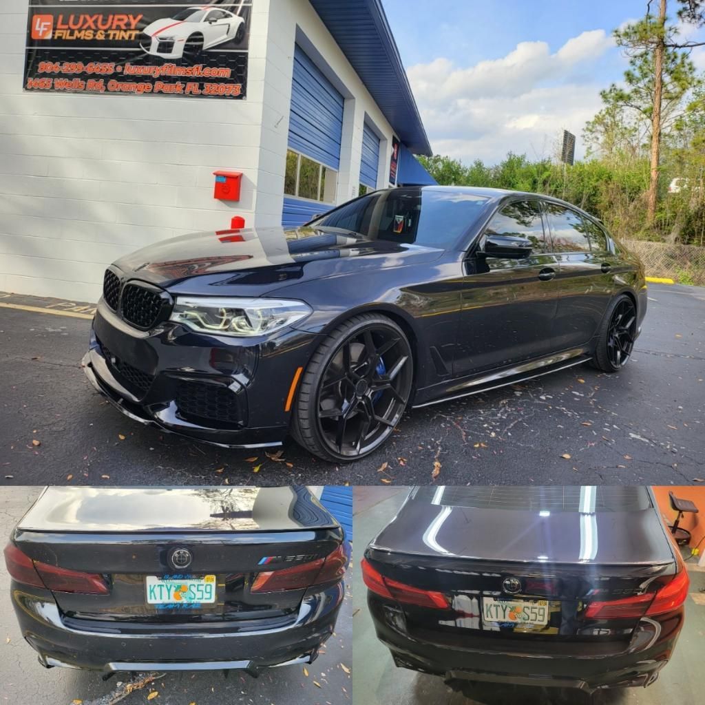 A black bmw is parked in front of a garage.
