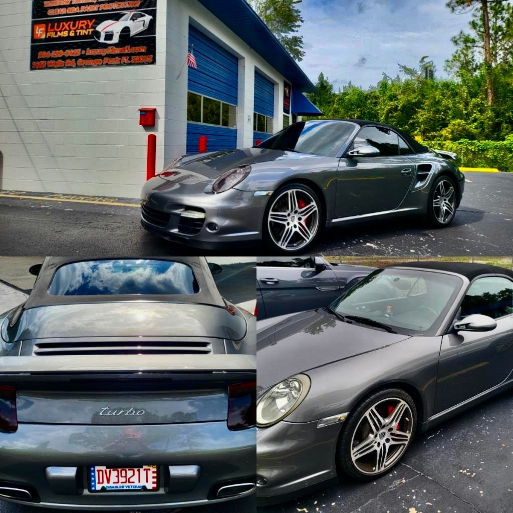 A porsche turbo is parked in front of a garage