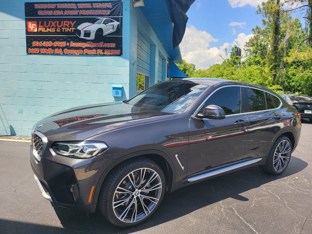 A bmw x4 is parked in front of a building.