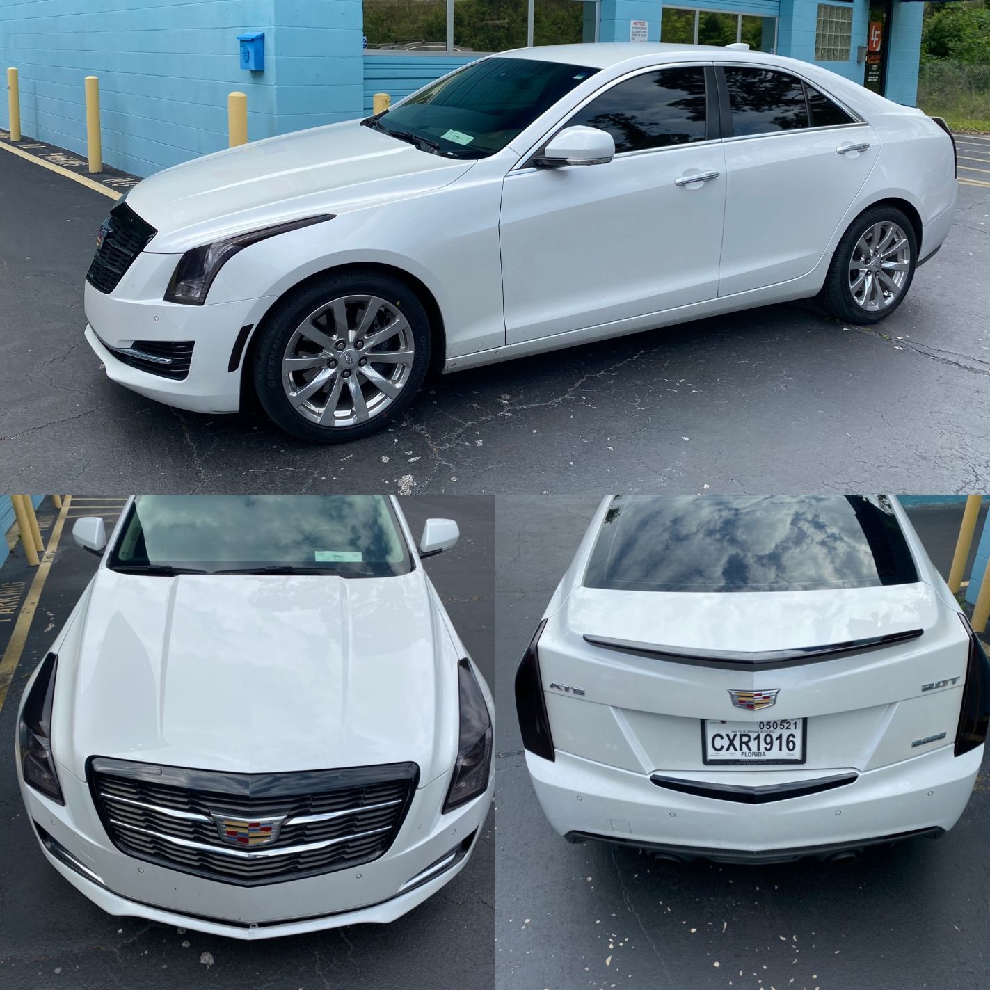 A white car is parked in front of a blue building.