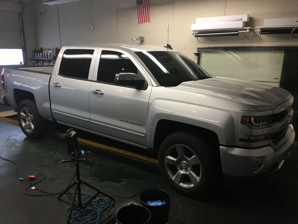 A silver pickup truck is parked in a garage.