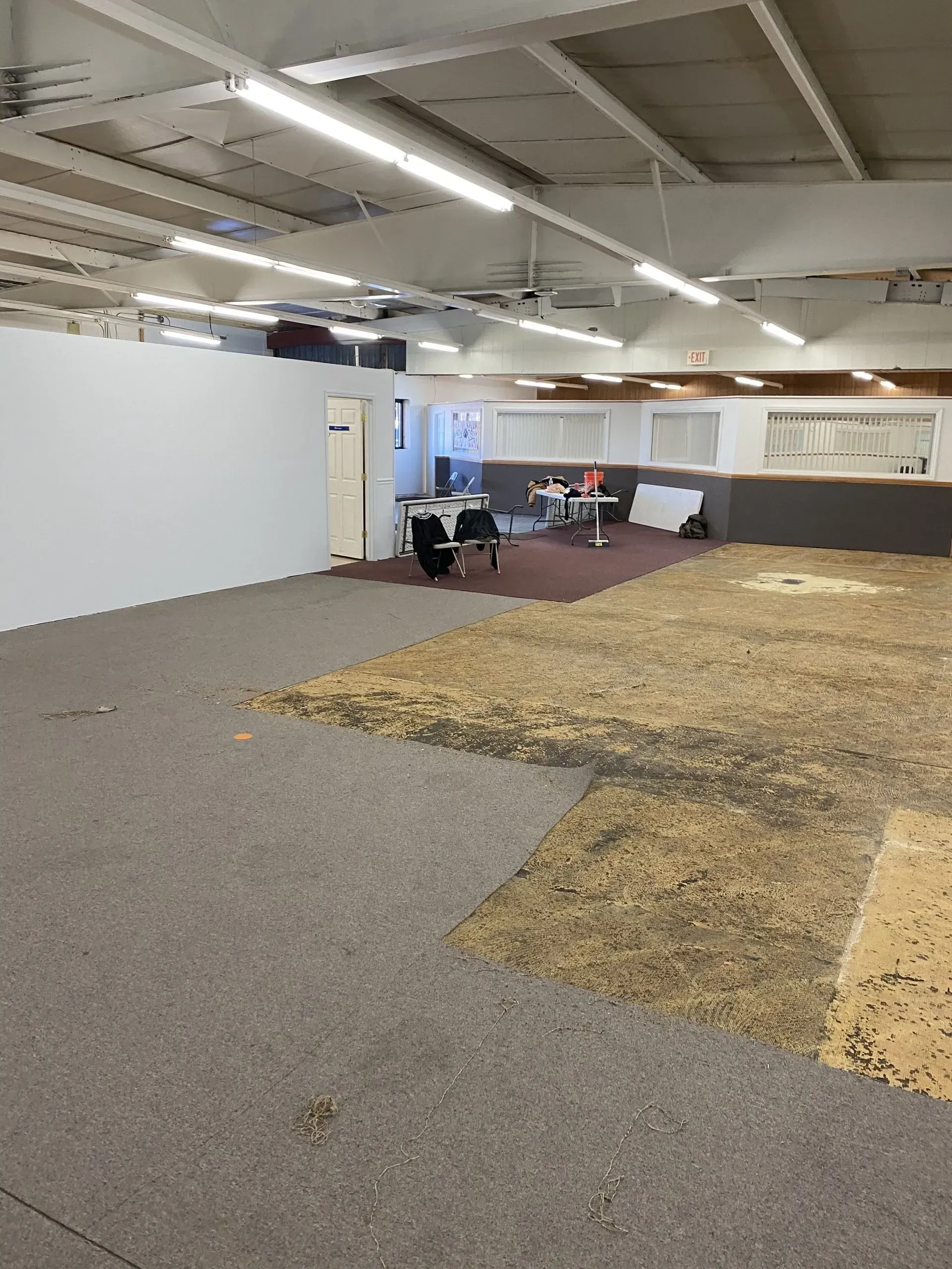 A large empty room with a carpeted floor and white walls.