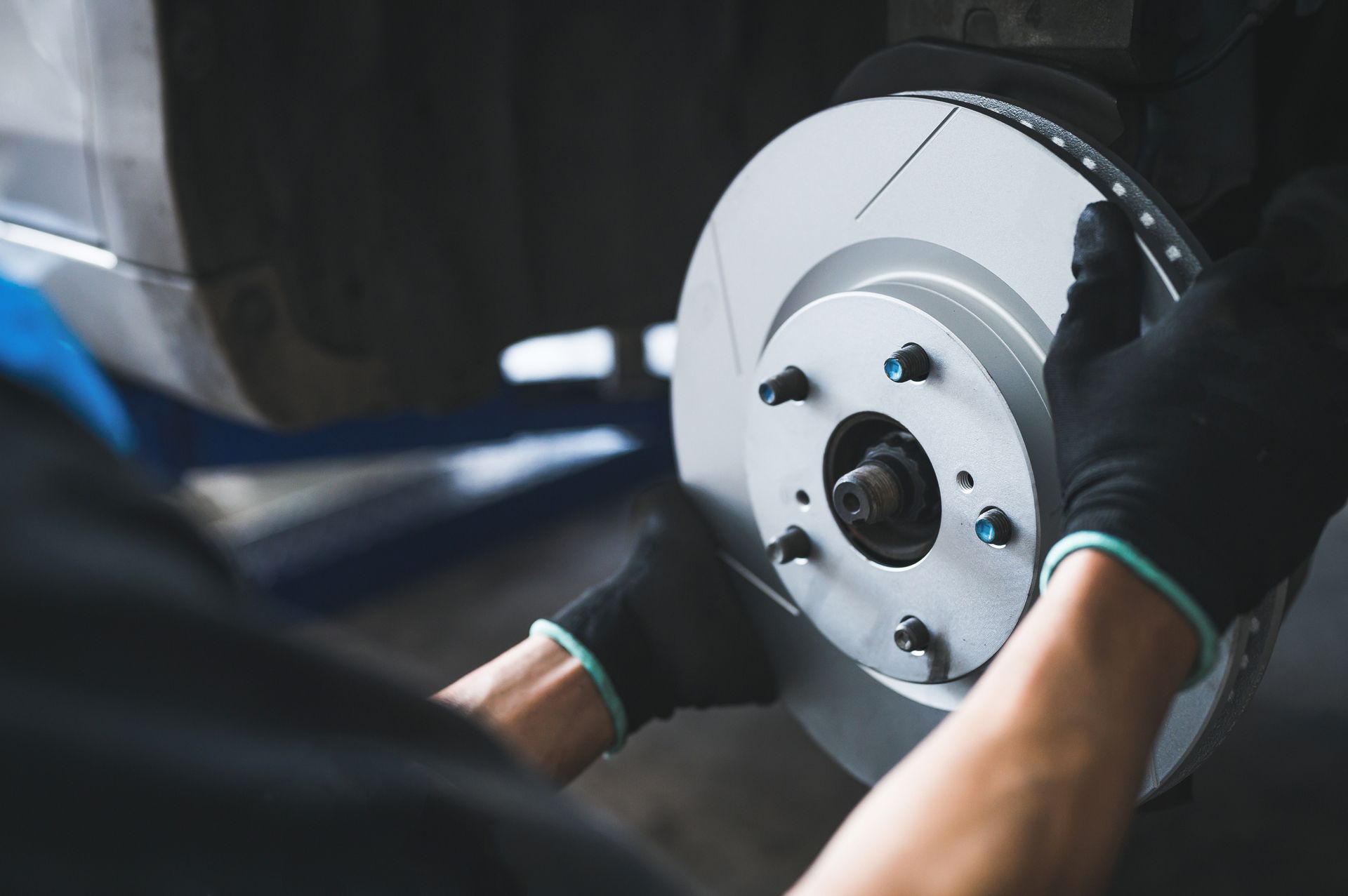 A person is fixing a brake disc on a car.