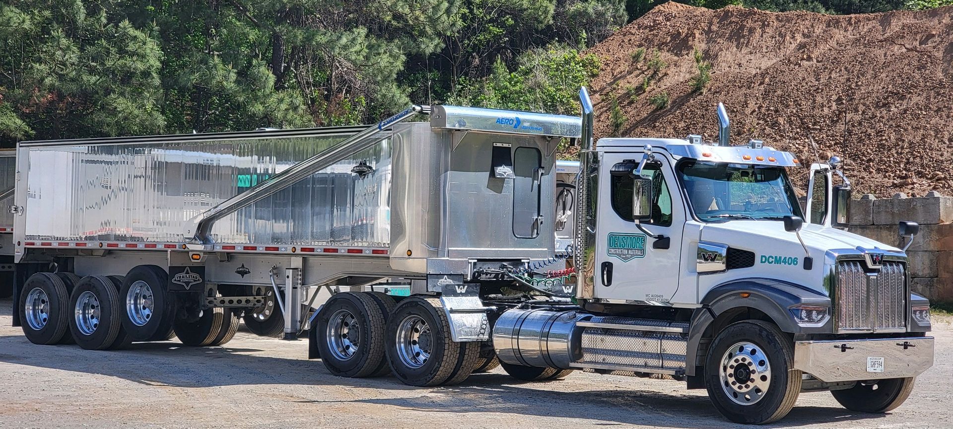 A blue dump truck is being loaded with gravel.