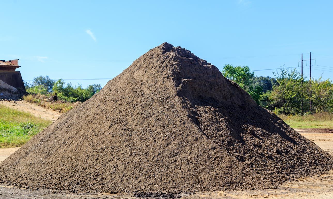 A large pile of dirt is sitting in a field