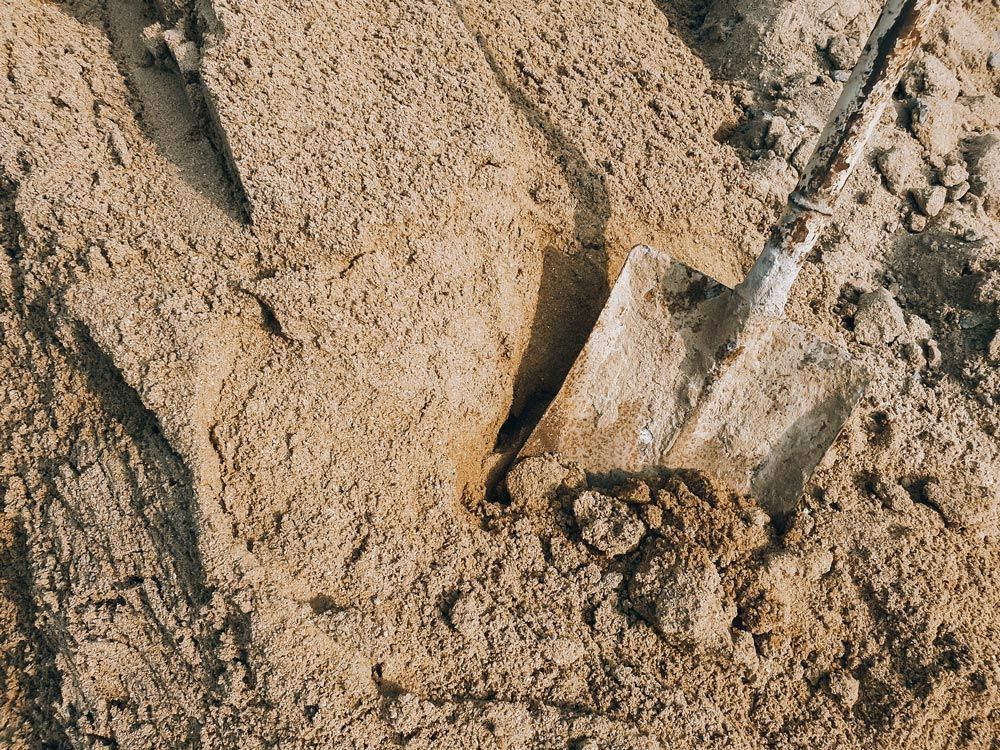 A shovel is digging in a pile of sand.