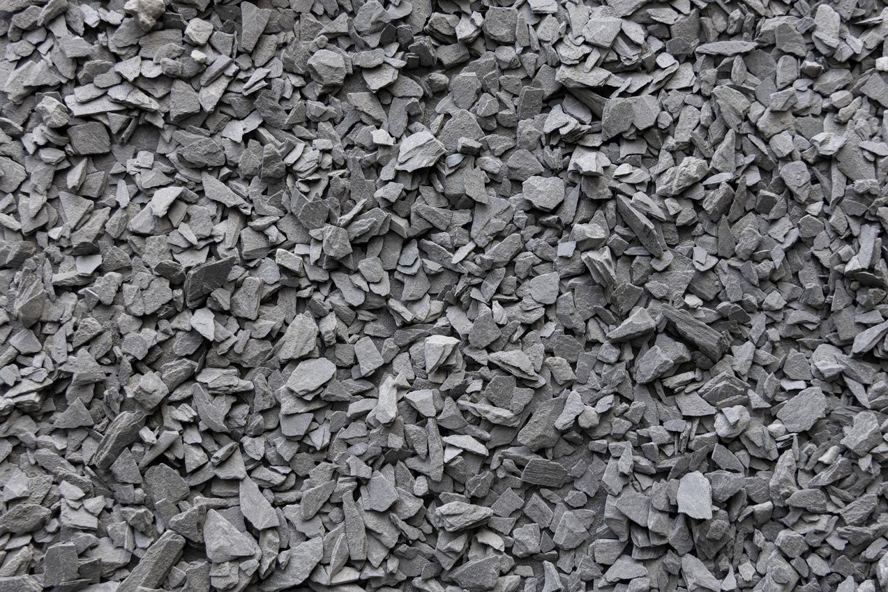 A pile of gray gravel is shown in a black and white photo.