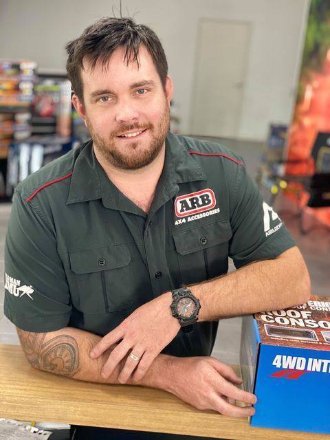 A Man Wearing An Arb Shirt Is Sitting At A Desk — Tech Tune Automotive and 4x4 ARB In Innisfail, QLD