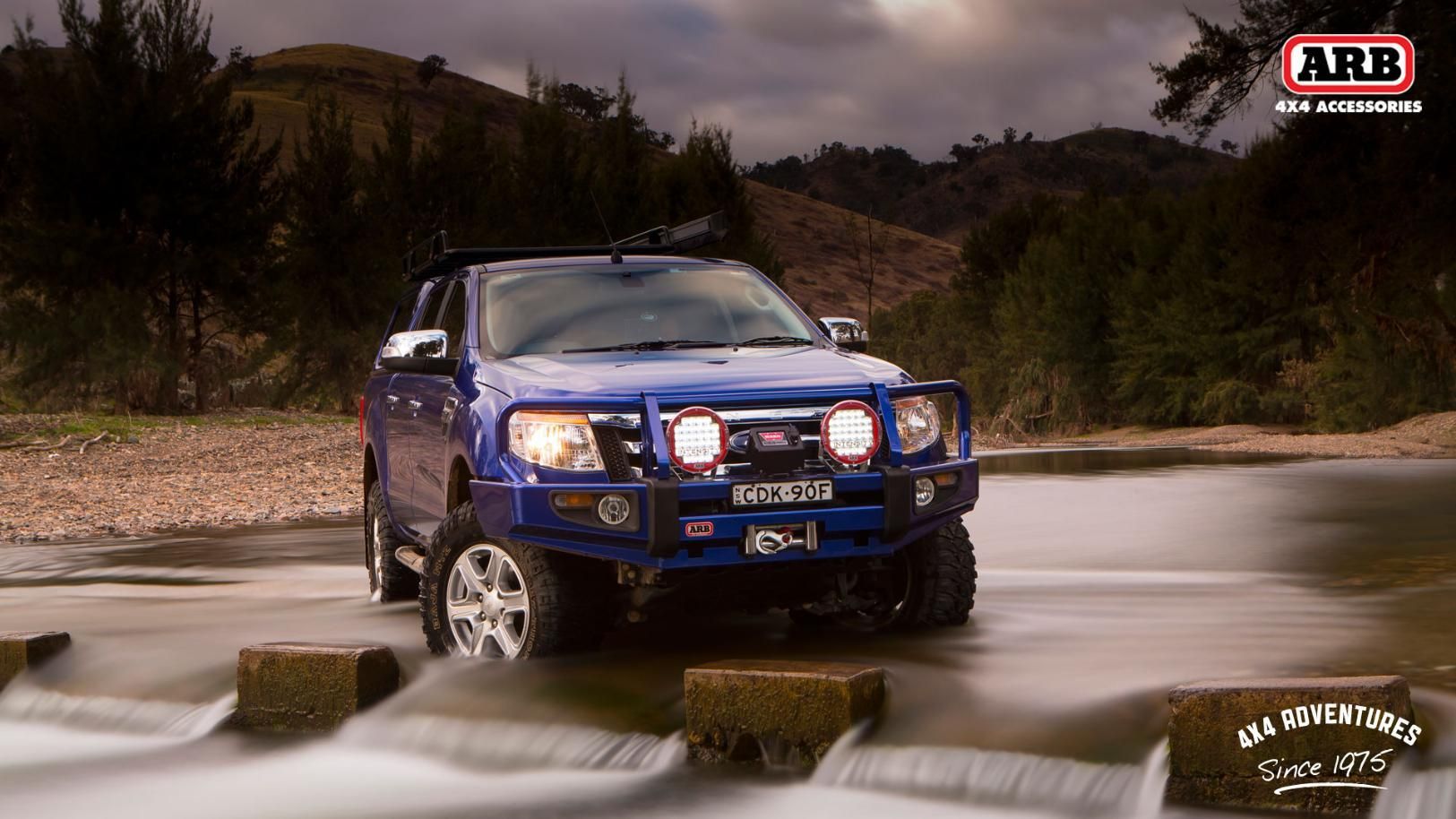 A Blue Truck Is Driving Through A River — Tech Tune Automotive and 4x4 ARB In Innisfail, QLD