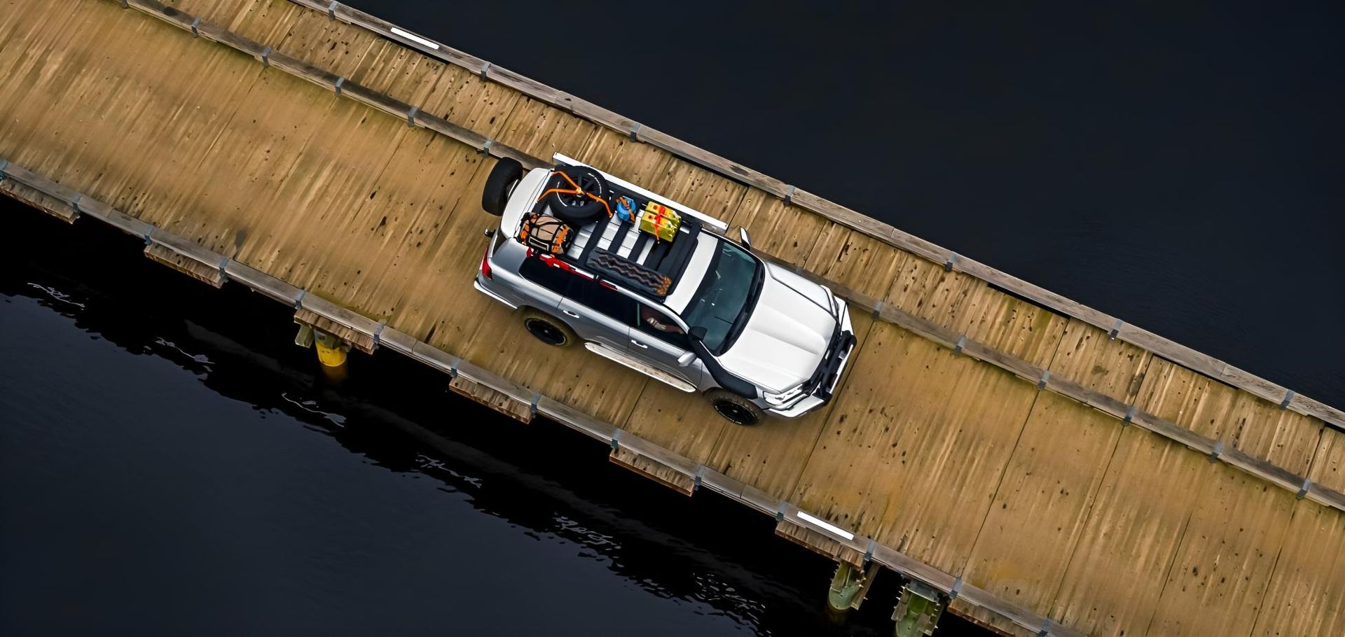 A Car Driving Across A Wooden Bridge Over A Body Of Water — Tech Tune Automotive and 4x4 ARB In Innisfail, QLD