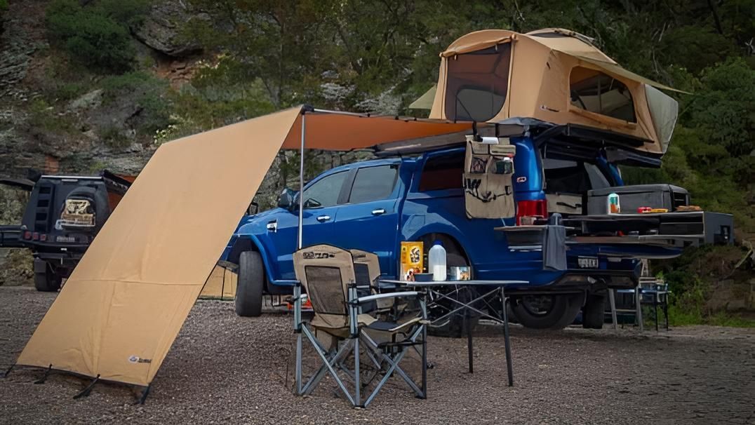 A Blue Truck With A Tent On Top Of It Is Parked In A Gravel Lot — Tech Tune Automotive and 4x4 ARB In Innisfail, QLD