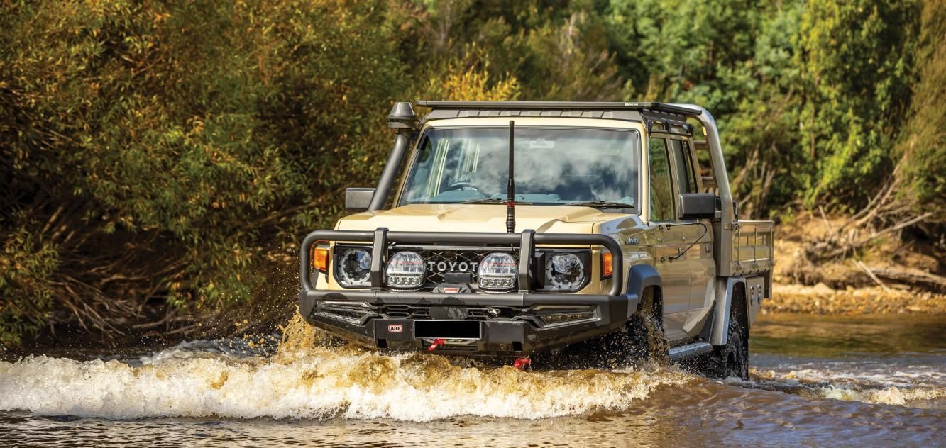 A Toyota Land Cruiser Is Driving Through A Muddy River — Tech Tune Automotive and 4x4 ARB In Mission Beach, QLD