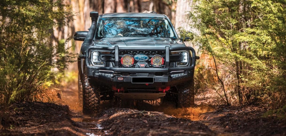 A Black 4x4 Vehicle Is Driving Through A Muddy Forest — Tech Tune Automotive and 4x4 ARB In Innisfail, QLD