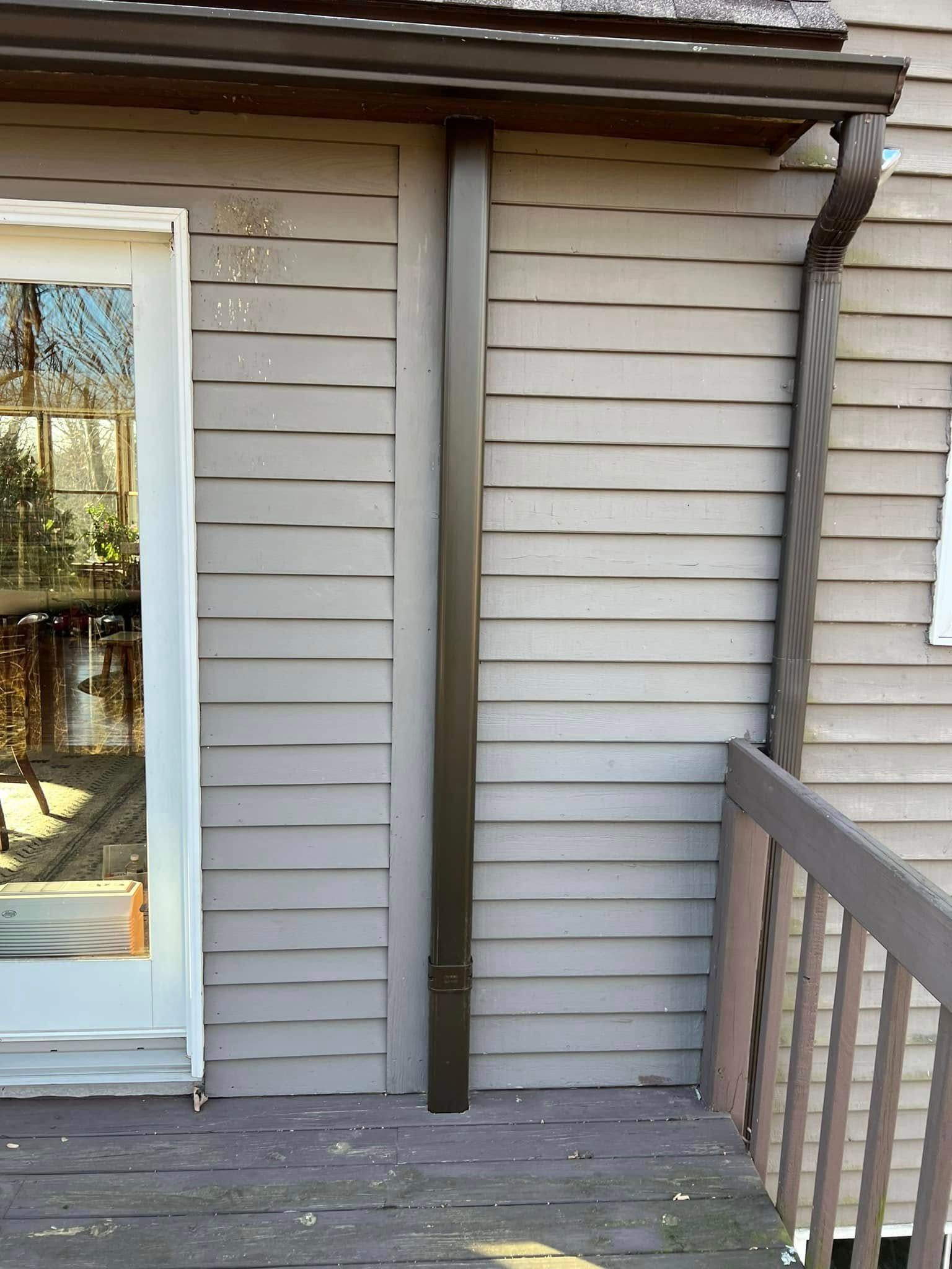 A house with a sliding glass door and a gutter