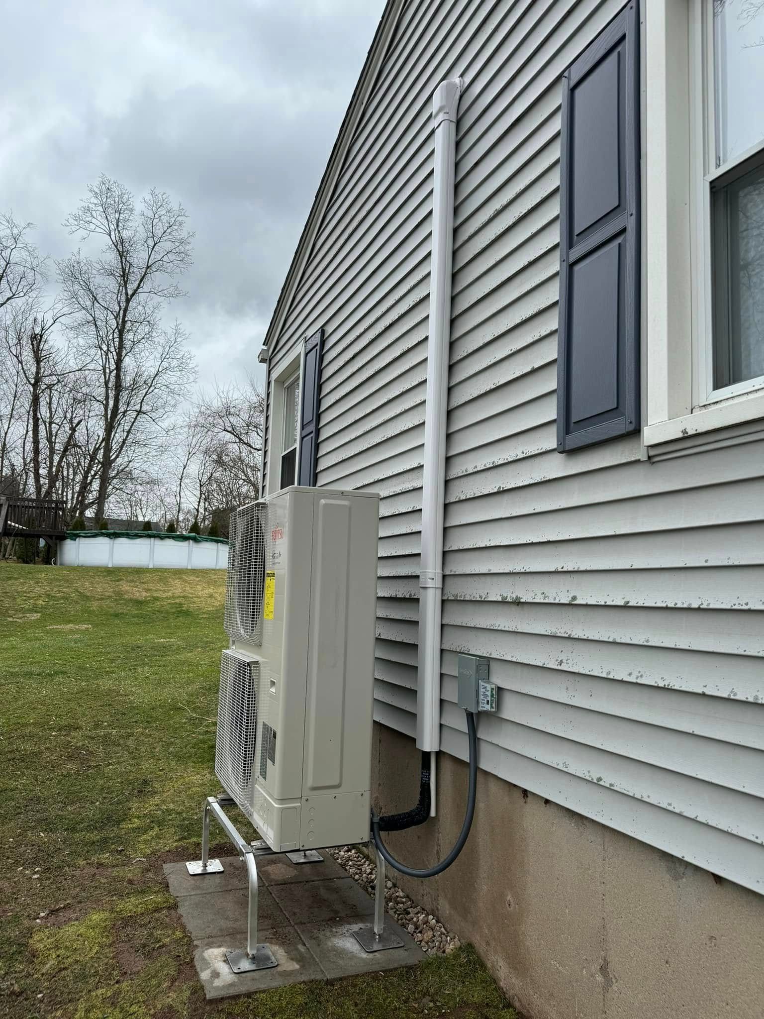 A house with a heater attached to the side of it.