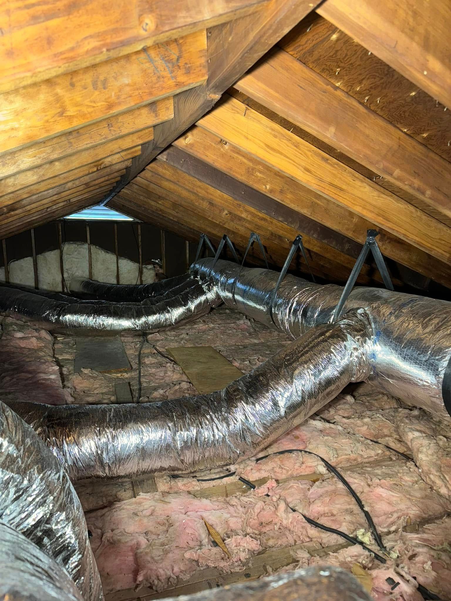 There are a lot of ducts in the attic of a house.