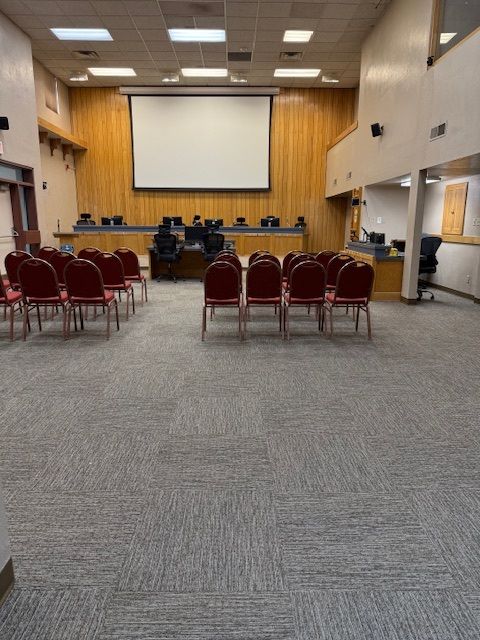 Two people unroll a golden yellow carpet in a room. Two people unroll a golden yellow carpet in a room.