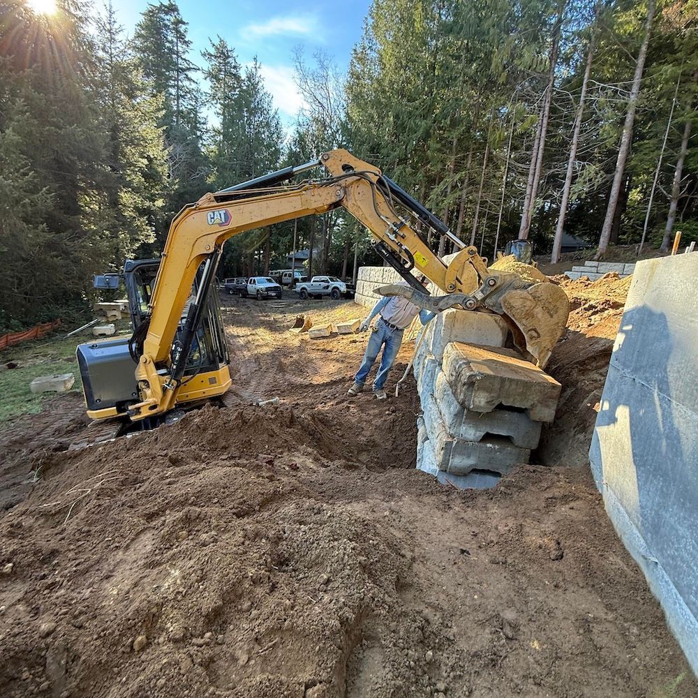 A yellow excavator is digging a hole in the ground.
