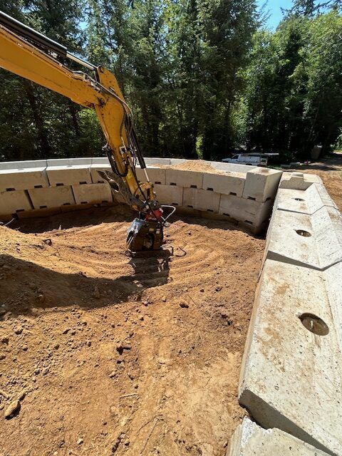 A yellow excavator is working on a construction site