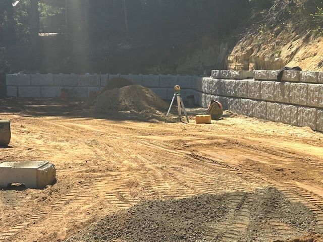 A concrete wall is being built on a dirt road.