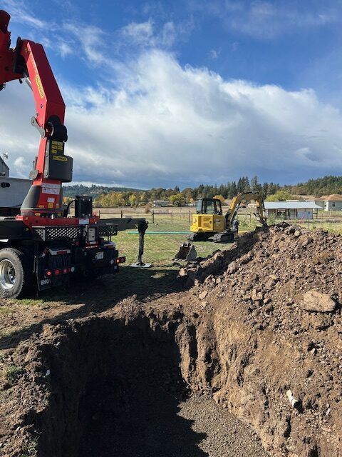 A red crane is sitting on top of a pile of dirt.