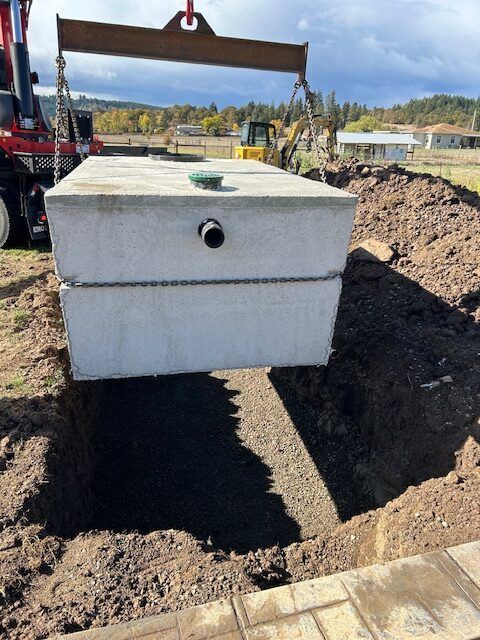 A large concrete box is being lifted by a crane