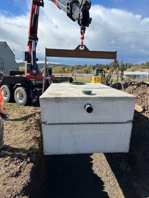 A large concrete box is being lifted by a crane