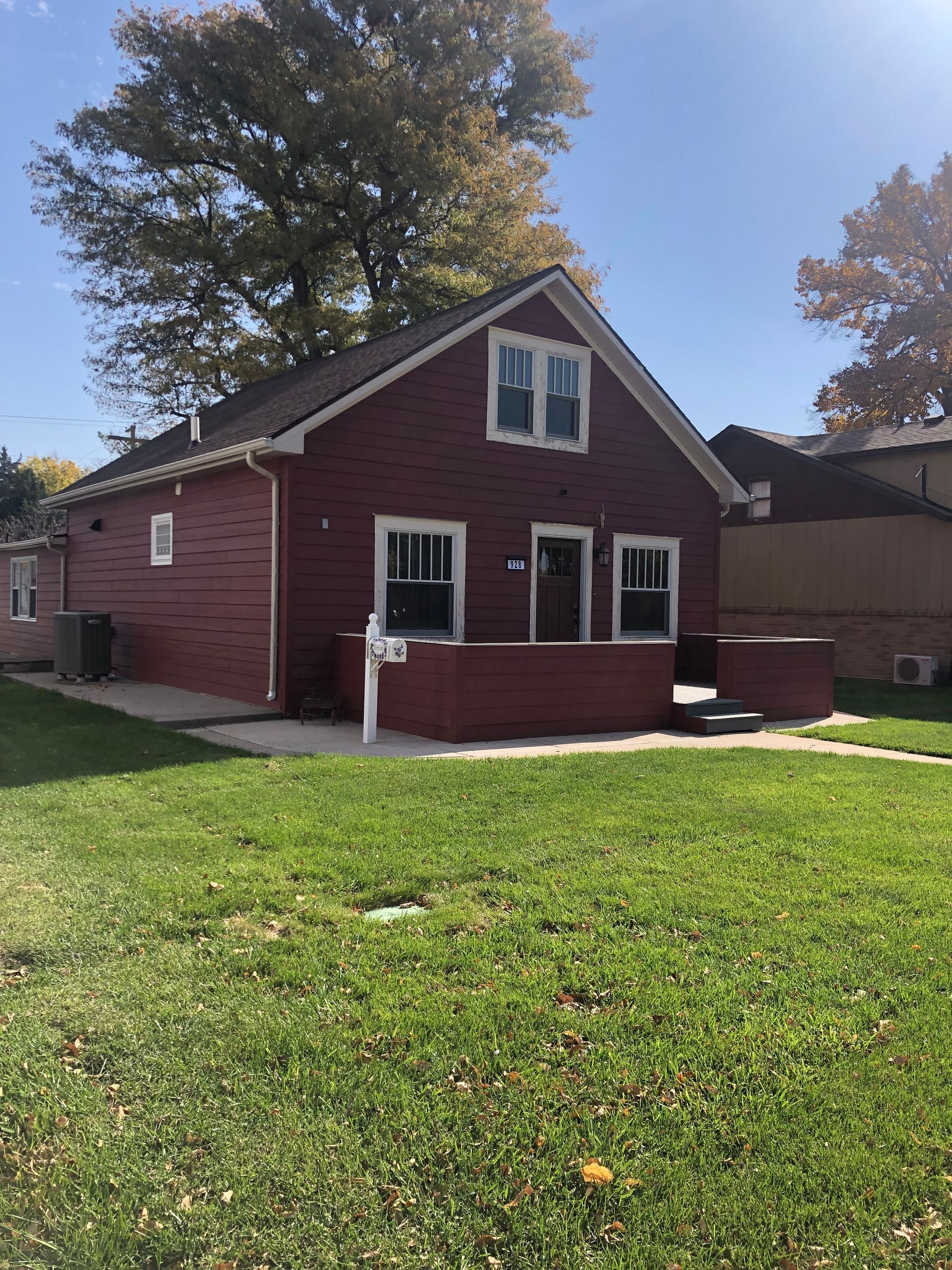 A red brick house with a large lawn in front of it